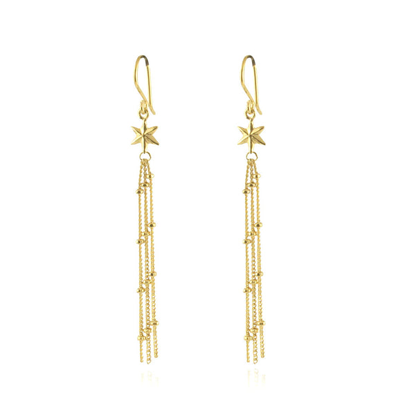 Gold hanging earrings with a star at the top and three delicate hanging chains below, on a white background
