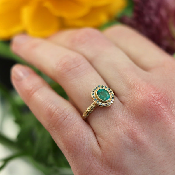 Oval Emerald And Blue Diamond Halo Ring