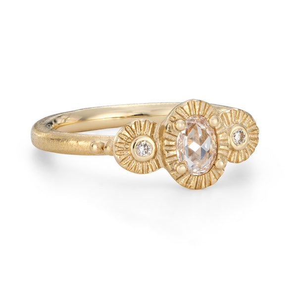 Gold ring with a central gemstone and smaller diamonds on a white background