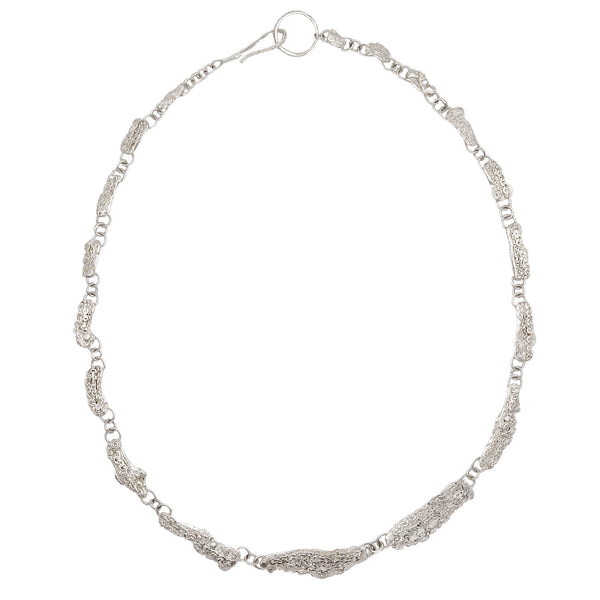 A silver-toned filigree chain necklace with a textured, wavy bar centerpiece, displayed on a clean white background.