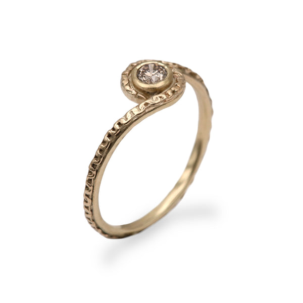 gold textured ring and brown diamond on white background