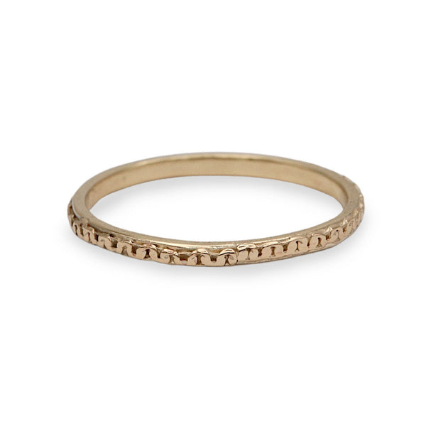 A thin yellow gold eternity ring with a textured, beaded outer band, shown on a plain white background.