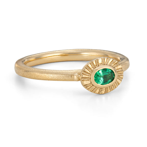 Gold ring with a green gemstone on a white background