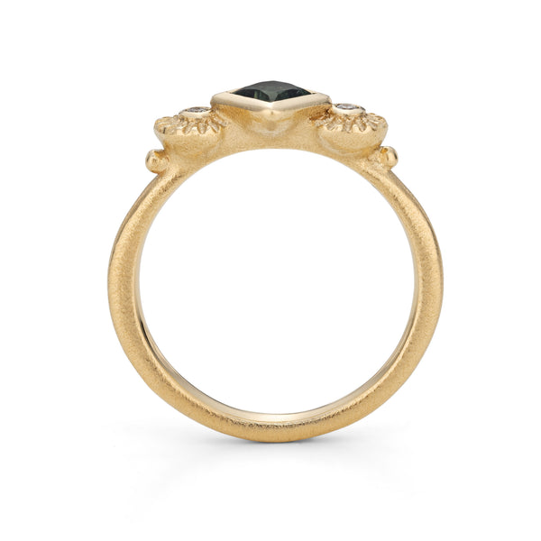 Gold ring with a black gemstone on a white background